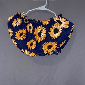 This is a bright colored crop top with sunflowers on it!